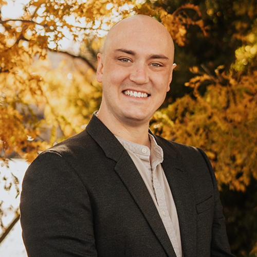 Justin Wilbert smiling in a black blazer