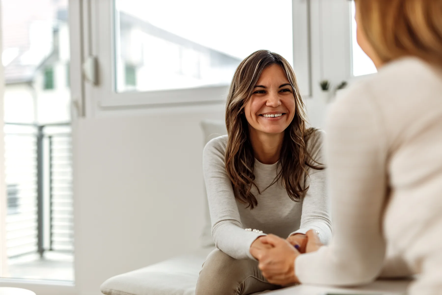 A client and counselor having a thoughtful conversation in a bright office