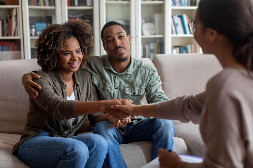 Two people on a couch, shaking hands